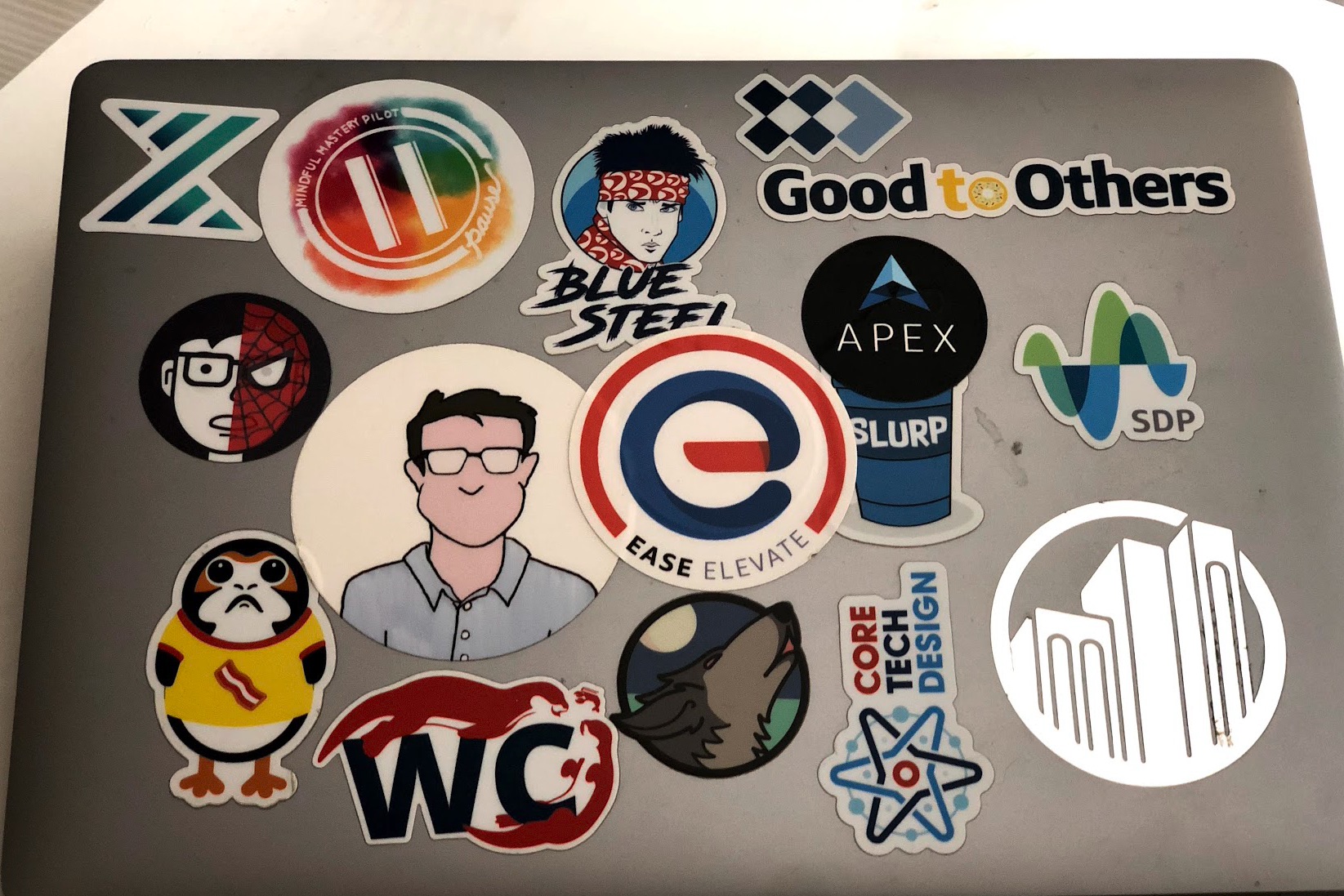 The lid of Jason's laptop, covered in stickers from teams, projects, and communities he's been part of over the years